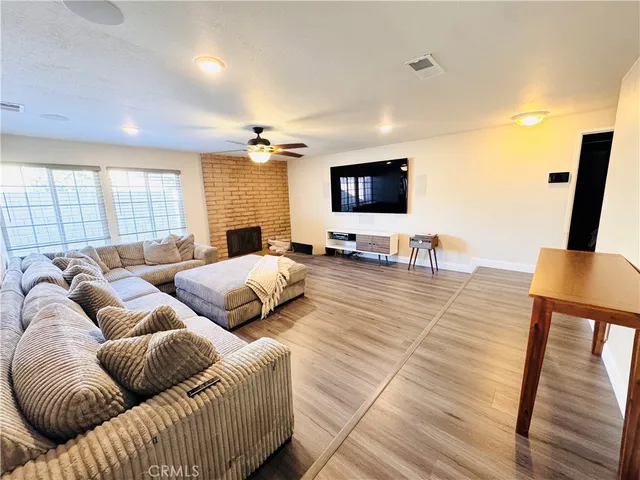 a living room with furniture wooden floor and a flat screen tv
