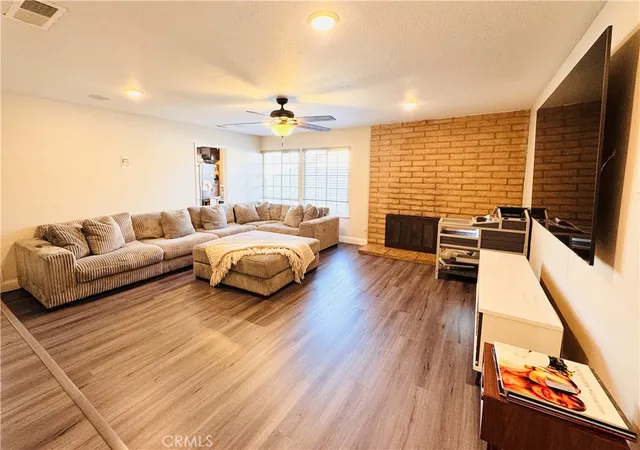 a living room with furniture kitchen view and a window
