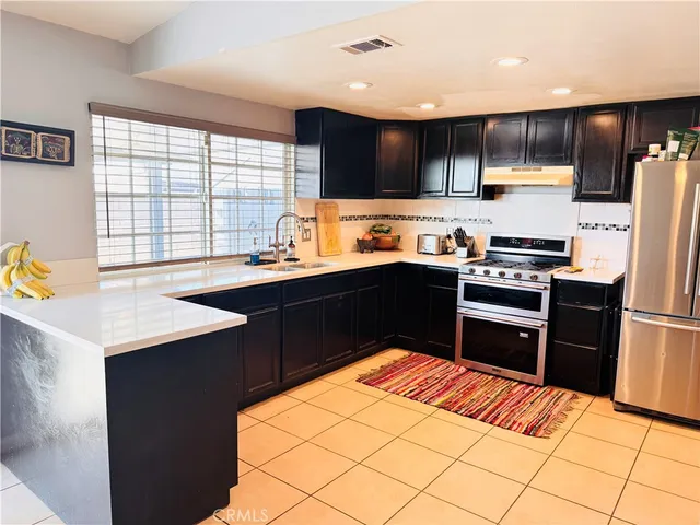 a kitchen with stainless steel appliances granite countertop a refrigerator and a stove