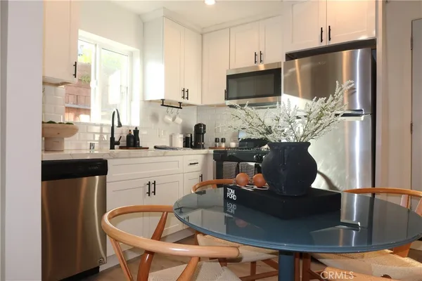 a kitchen with a table chairs refrigerator and microwave
