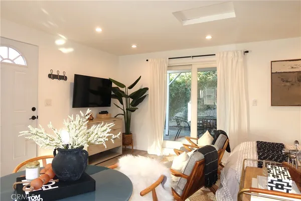 a living room with furniture a flat screen tv and a floor to ceiling window