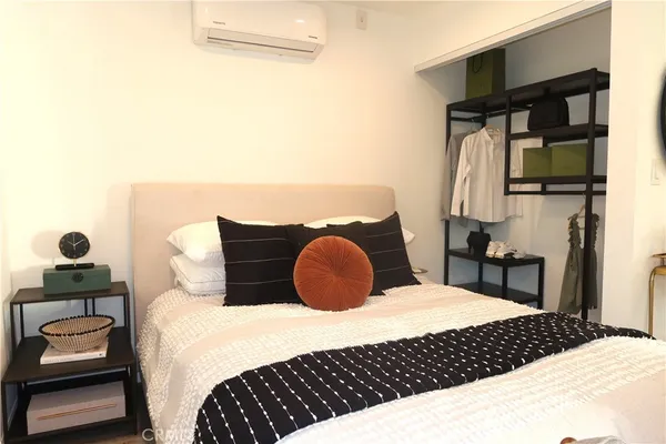 a bedroom with a bed and a lamp on dresser