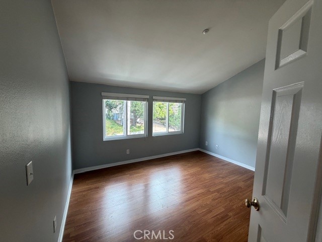 3709 Las Flores Canyon Road, Unit D Malibu, CA 90265 - Photo 22 of 33 an empty room with wooden floor and windows