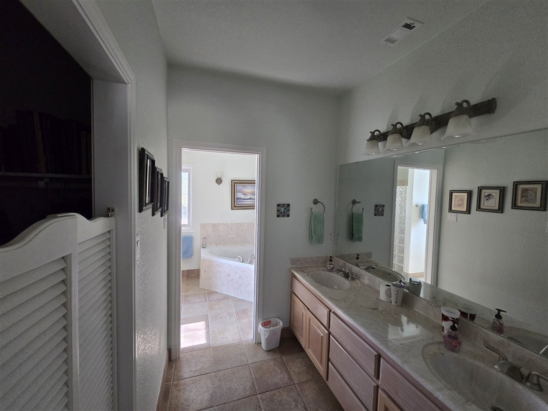 543 County Road 4620 Kempner, TX 76539 - Photo 14 of 36 a bathroom with a double vanity sink a toilet and shower