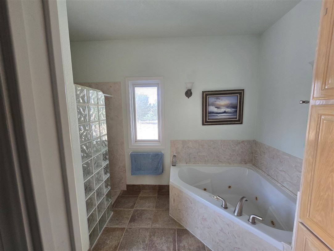 543 County Road 4620 Kempner, TX 76539 - Photo 15 of 36 a bathroom with a bathtub a window and a shower