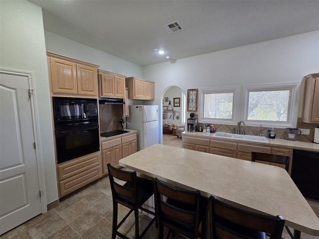 543 County Road 4620 Kempner, TX 76539 - Photo 17 of 36 a kitchen with a table chairs refrigerator and cabinets