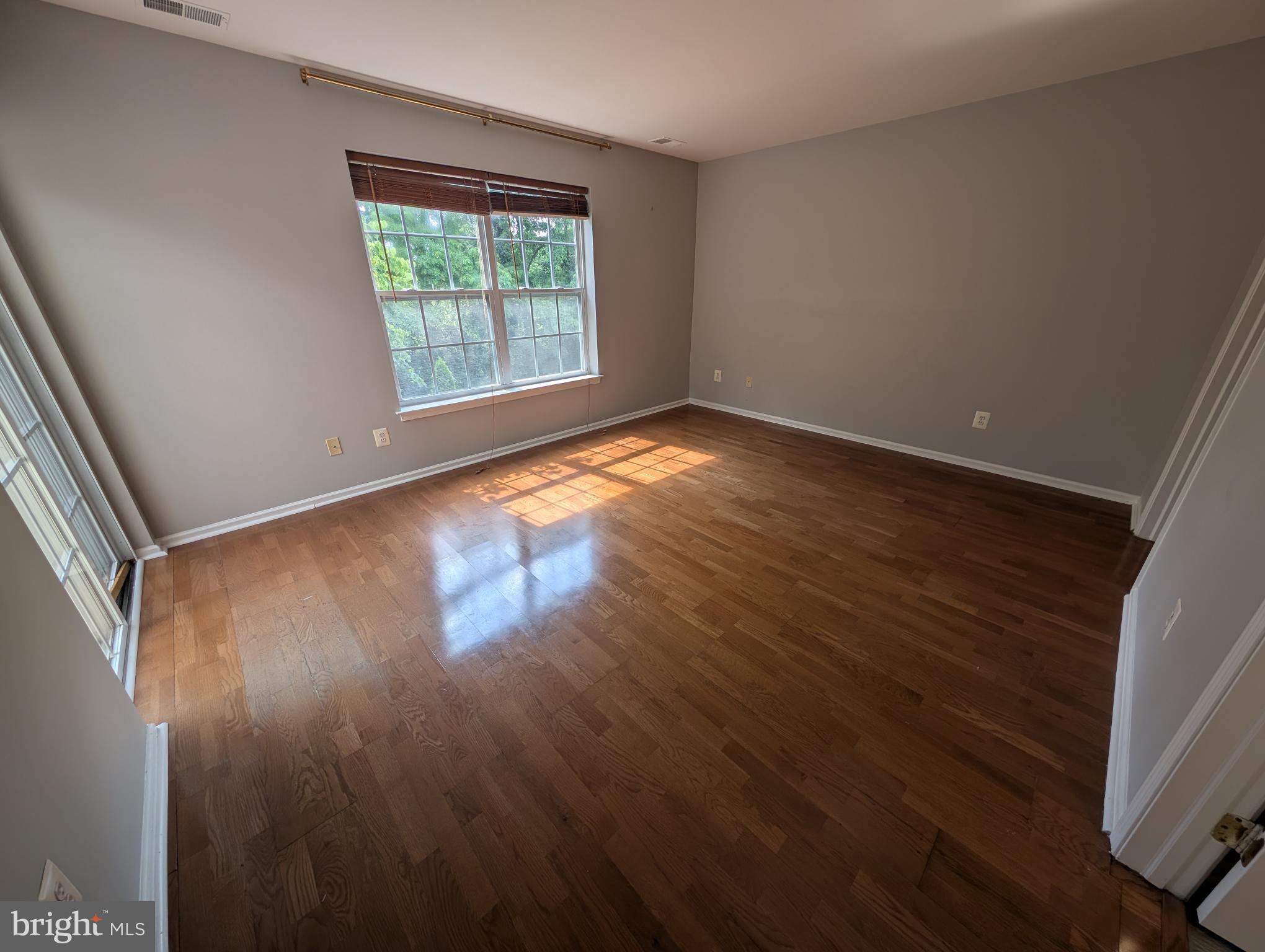 204 River Birch Circle, Unit 204 Kennett Square, PA 19348 - Photo 14 of 24 an empty room with wooden floor and windows