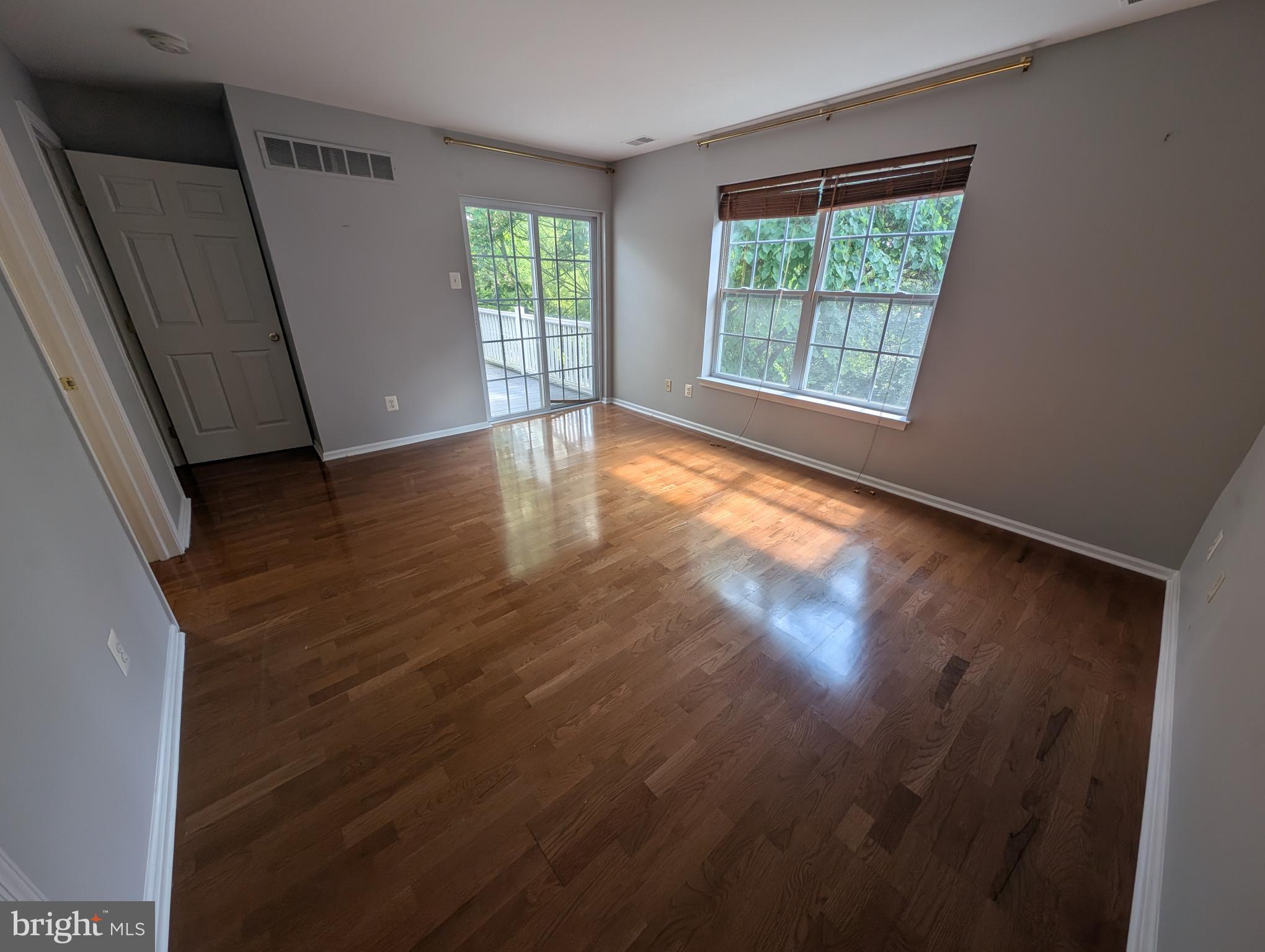 204 River Birch Circle, Unit 204 Kennett Square, PA 19348 - Photo 15 of 24 an empty room with wooden floor and windows