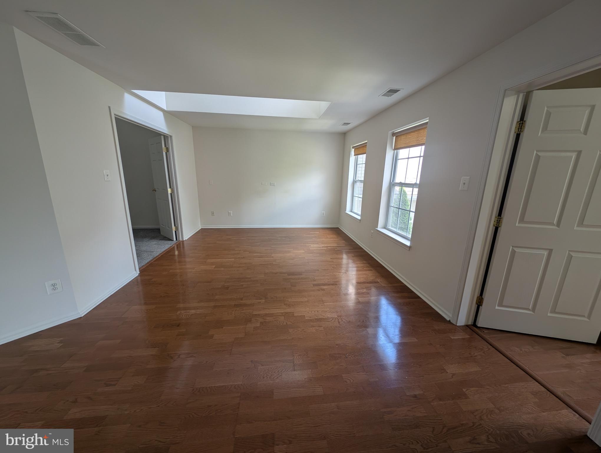 204 River Birch Circle, Unit 204 Kennett Square, PA 19348 - Photo 3 of 24 a view of an empty room with wooden floor and a window