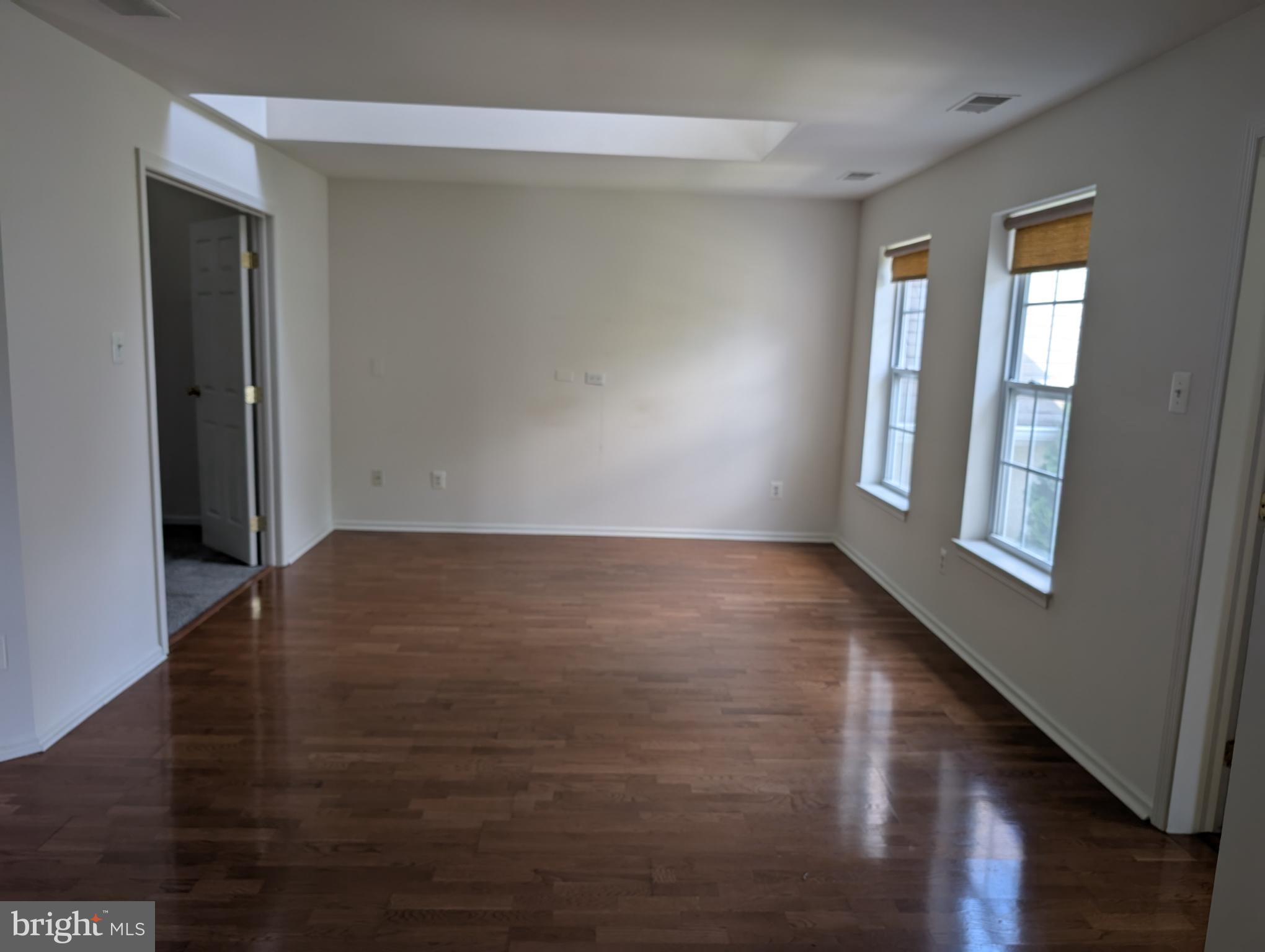 204 River Birch Circle, Unit 204 Kennett Square, PA 19348 - Photo 4 of 24 wooden floor in an empty room with a window