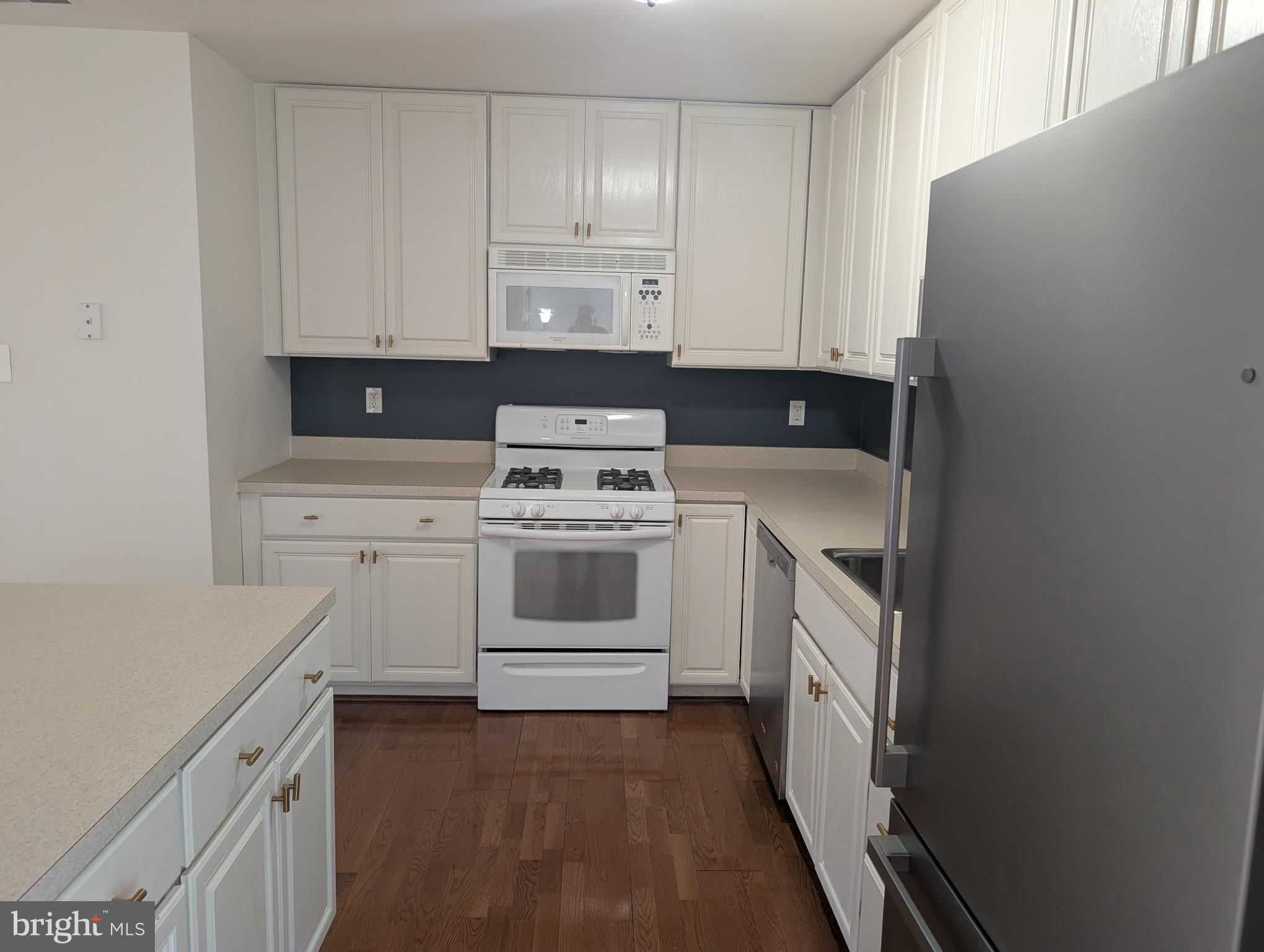 204 River Birch Circle, Unit 204 Kennett Square, PA 19348 - Photo 6 of 24 a kitchen with white cabinets and white appliances