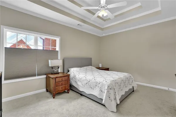 a spacious bedroom with a bed and a chandelier