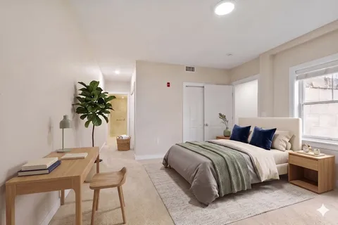 a bedroom with a bed and a potted plant