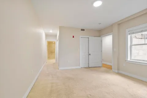 an empty room with windows and closet