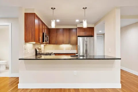 a kitchen with kitchen island granite countertop a stove a sink and a refrigerator