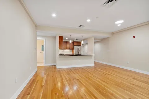 a view of empty room with wooden floor