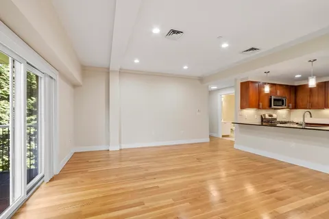 a view of a kitchen with kitchen island a sink wooden floor and a counter top space