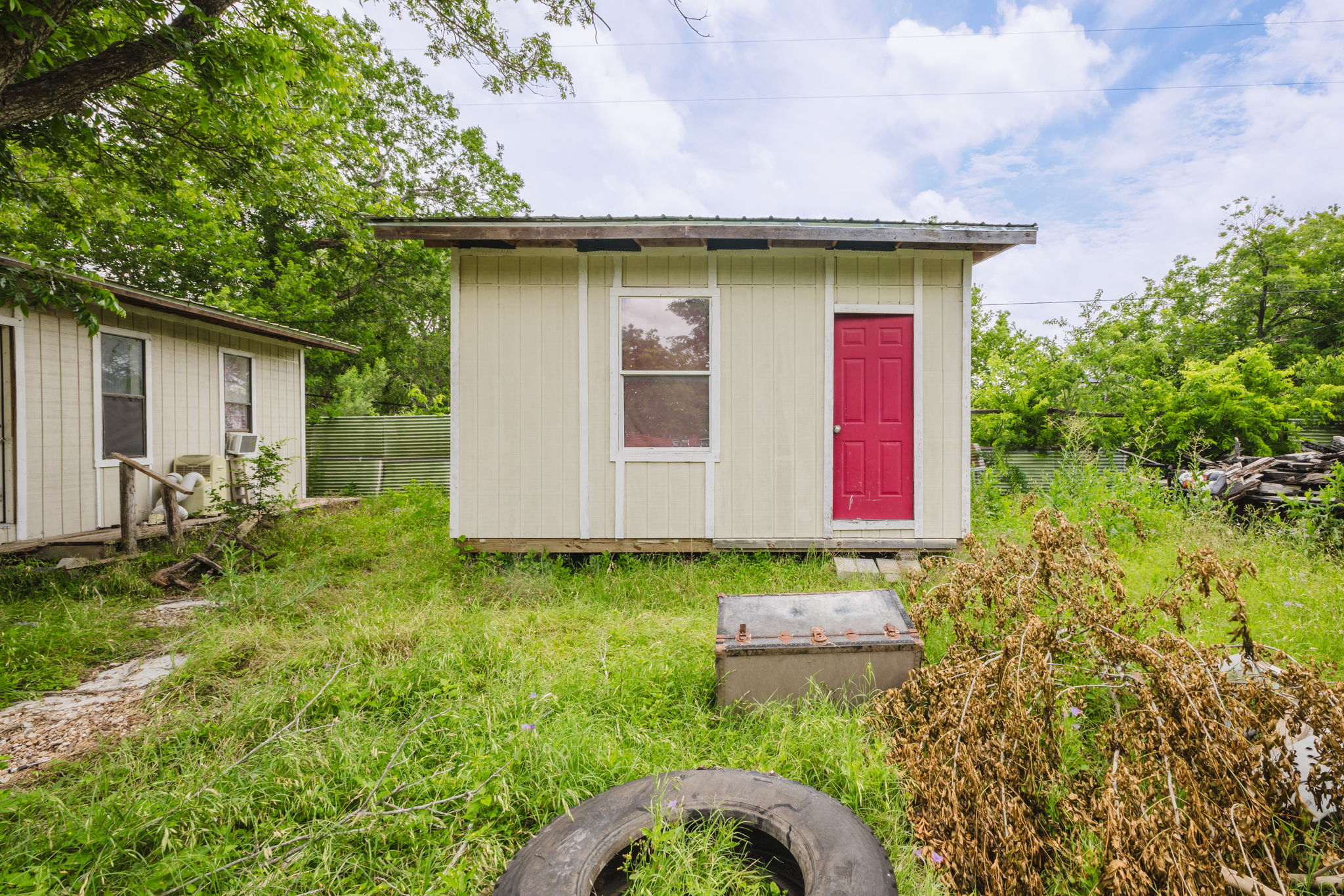 6803 Viewing Place Austin, TX 78719 - Photo 12 of 20 A charming compact shed offers additional storage or potential for creative use, nestled in a verdant setting.