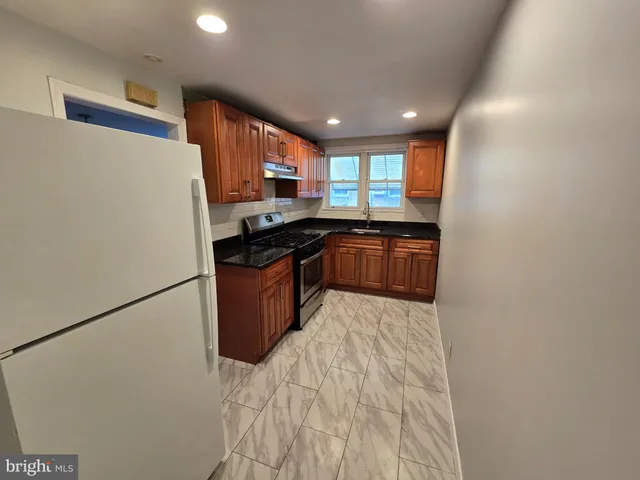 a kitchen with stainless steel appliances granite countertop a stove a sink and a refrigerator