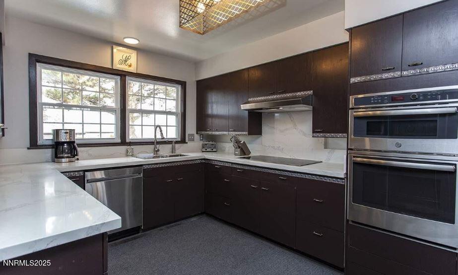 7050 Pembroke Drive Reno, NV 89502 - Photo 11 of 32 a kitchen with stainless steel appliances kitchen island granite countertop a stove and a sink