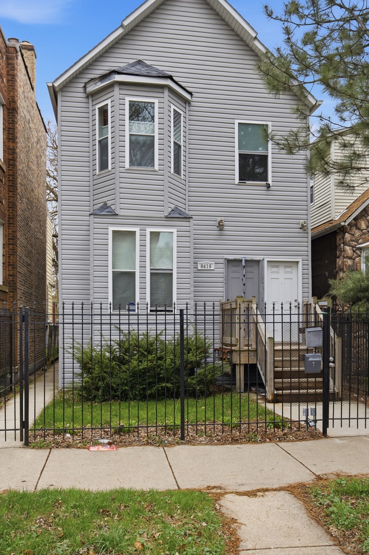 6418 South Rhodes Avenue Chicago, IL 60637 - Photo 1 of 19 a front view of a house with a garden