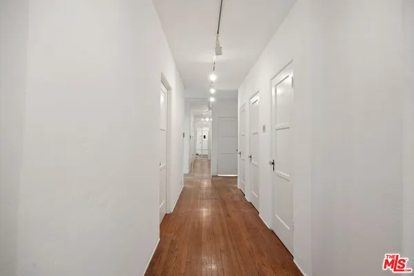 a view of a hallway with wooden floor