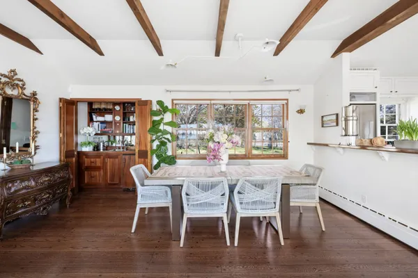 a dining room with furniture window and wooden floor