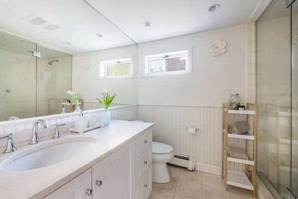 a bathroom with a granite countertop sink a toilet and shower