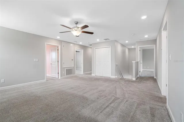 a view of an empty room with a ceiling fan