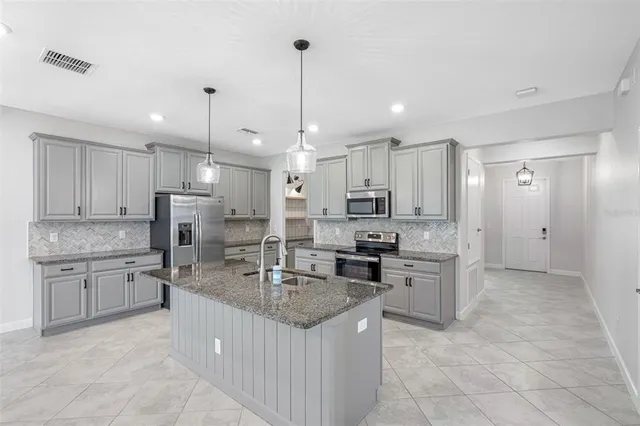 a kitchen with stainless steel appliances granite countertop a sink stove and refrigerator