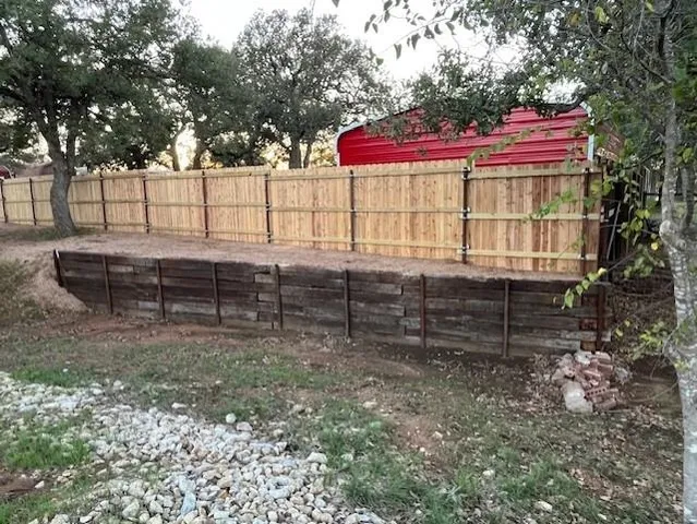 a view of a yard with wooden fence