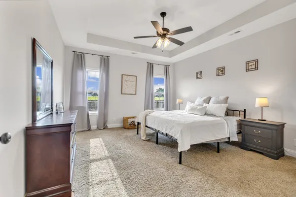 a spacious bedroom with a bed and a chandelier