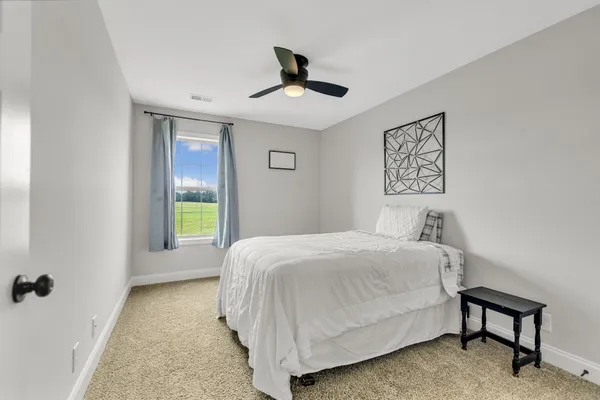 a bedroom with a bed and a painting on the wall