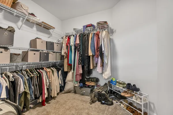 a view of walk in closet with clothes and shoes