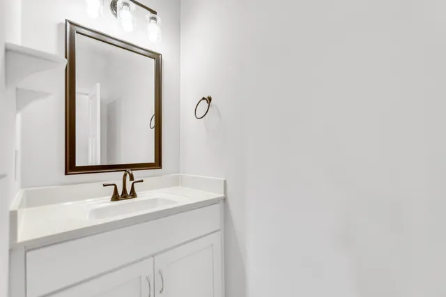 a bathroom with a sink vanity and a mirror