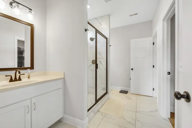 a spacious bathroom with a mirror sink and shower