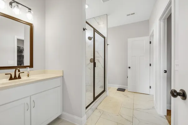 a spacious bathroom with a mirror sink and shower
