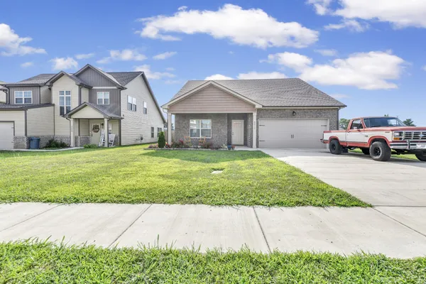 a front view of a house with a garden and yard