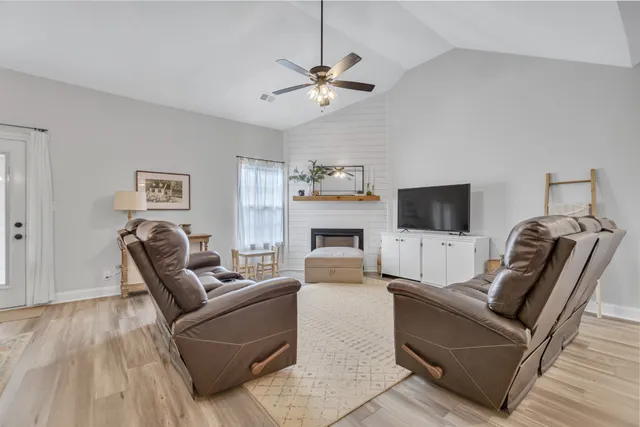 a living room with furniture a flat screen tv and a fireplace
