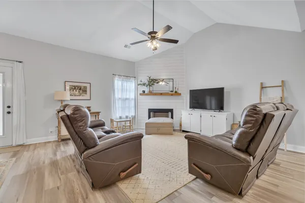 a living room with furniture a flat screen tv and a fireplace