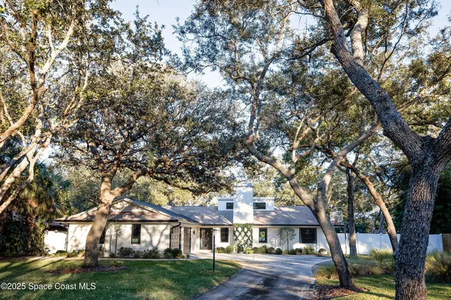 a view of residential houses with yard and trees