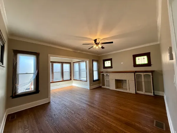a view of an empty room with window and wooden floor