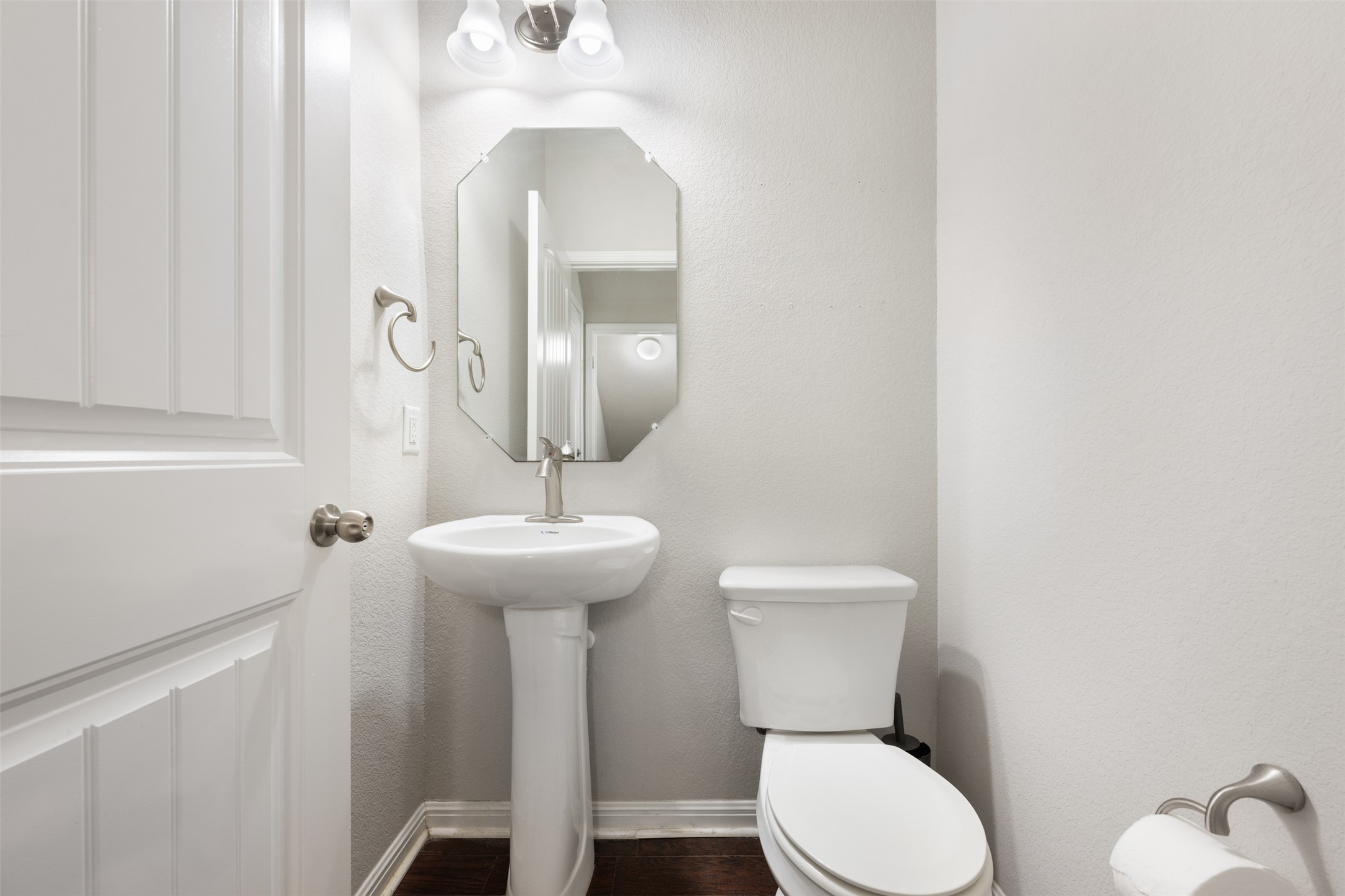 211 Parable Cove Pflugerville, TX 78660 - Photo 18 of 40 Pedestal sink with brushed nickel faucet, an octagonal mirror, and overhead vanity lighting