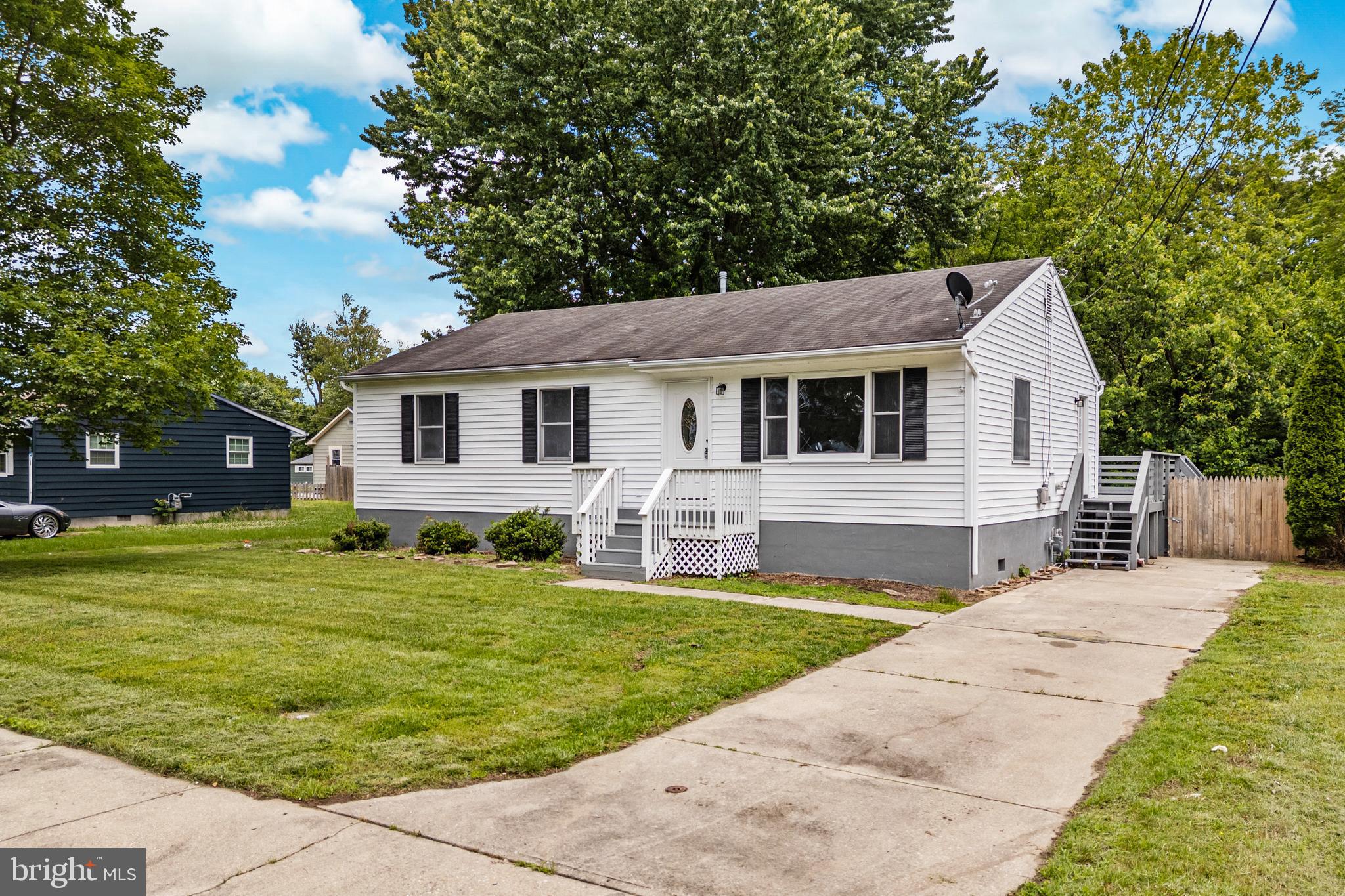 88 Delaware Drive Pennsville, NJ 08070 - Photo 2 of 26 a front view of a house with a garden and trees