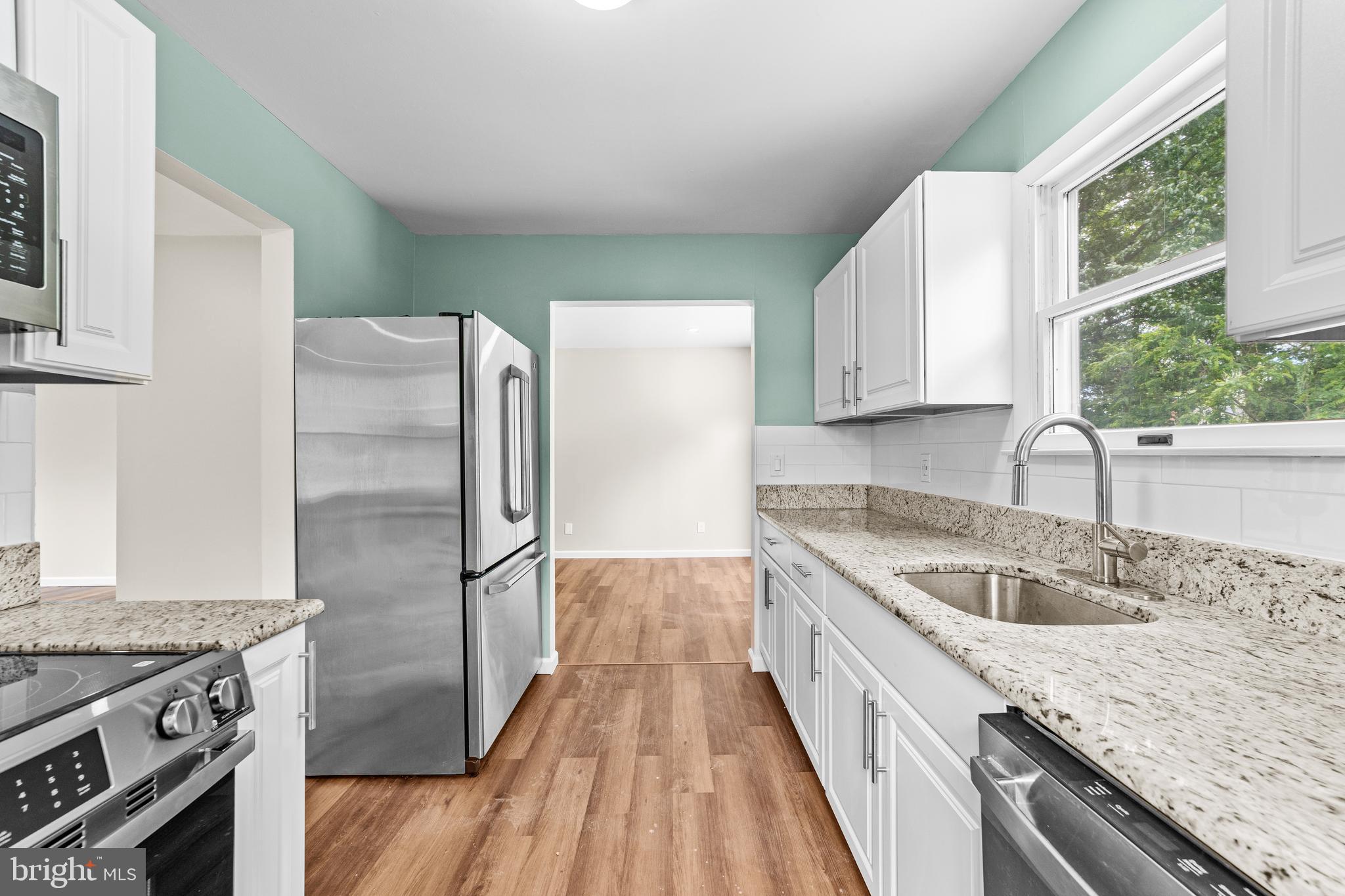 88 Delaware Drive Pennsville, NJ 08070 - Photo 4 of 26 a kitchen with granite countertop a sink stove and refrigerator