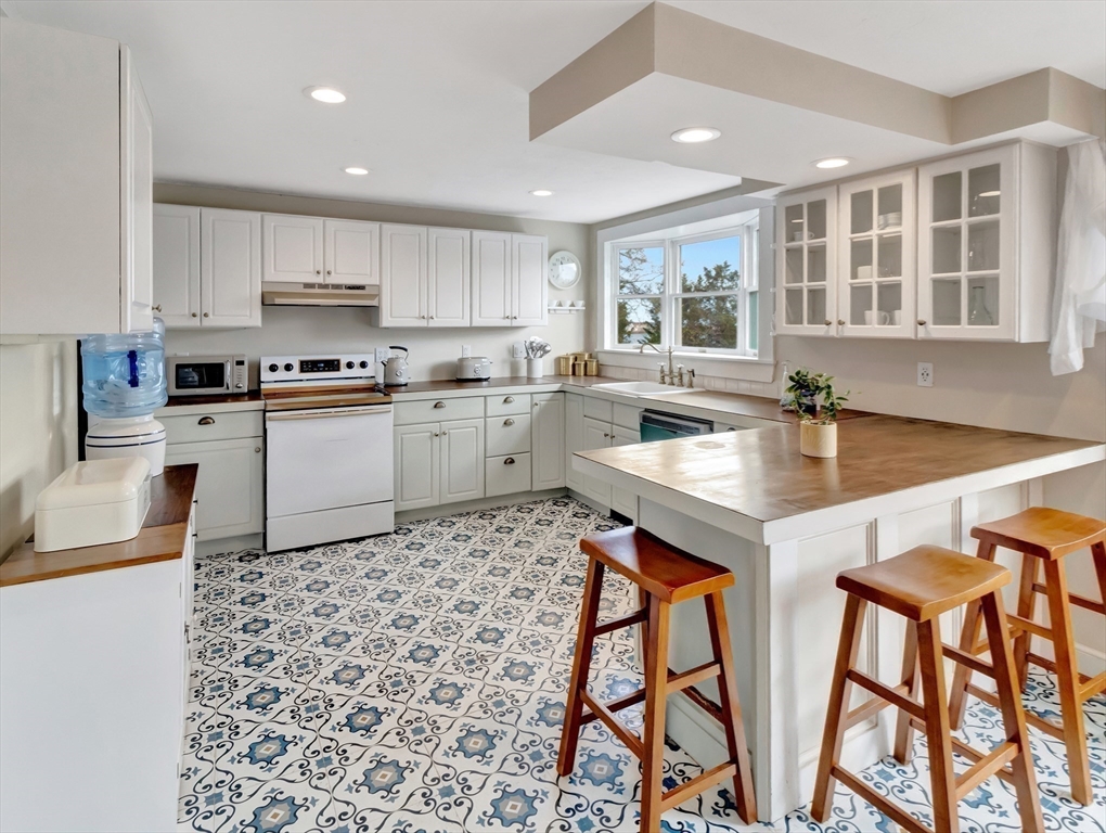54 Salisbury Street Hull, MA 02045 - Photo 6 of 38 a kitchen with a sink a stove and cabinets