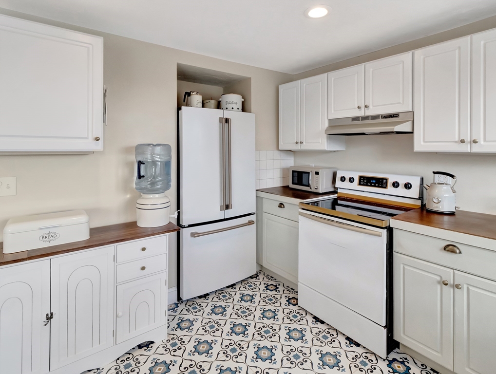 54 Salisbury Street Hull, MA 02045 - Photo 7 of 38 a kitchen with white cabinets and white appliances