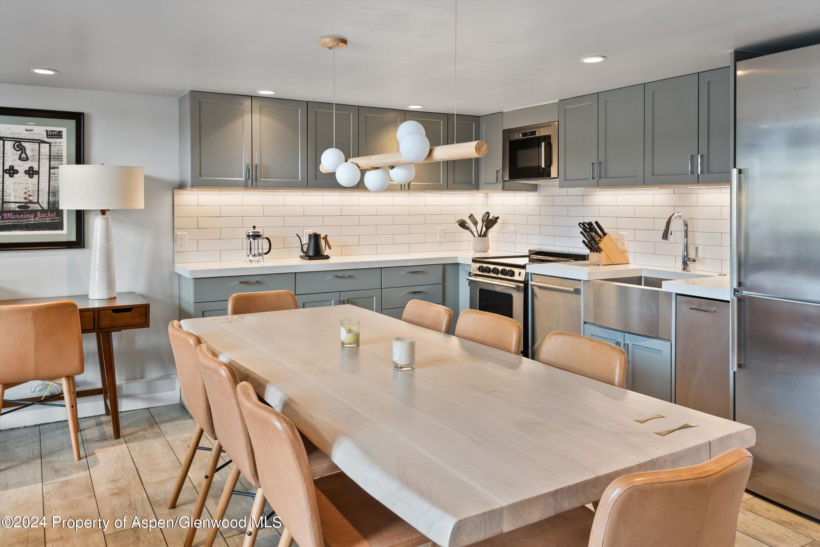 800 South Mill Street, Unit 102C Aspen, CO 81611 - Photo 12 of 23 a kitchen with kitchen island a stove a table and chairs