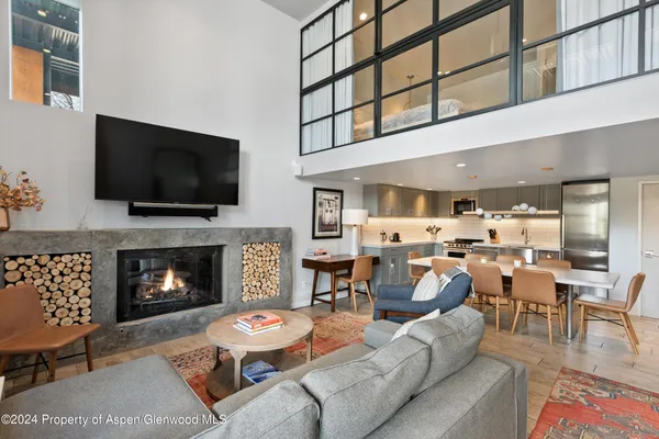 a living room with furniture a flat screen tv and a fireplace