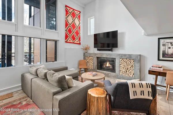a living room with furniture a flat screen tv and a fireplace